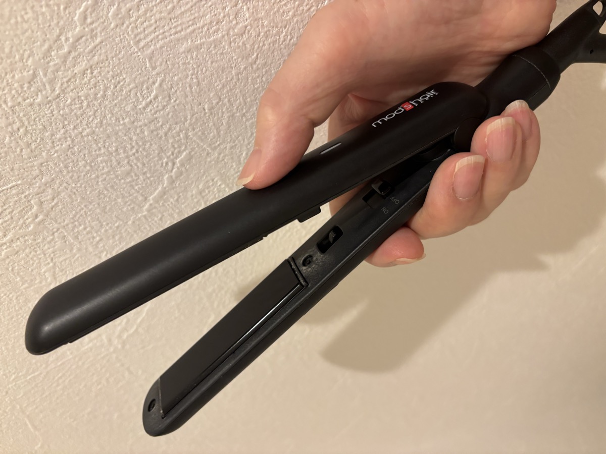 mod's hairのミニアイロンを手で持っているところ。手のひらに収まるサイズ感